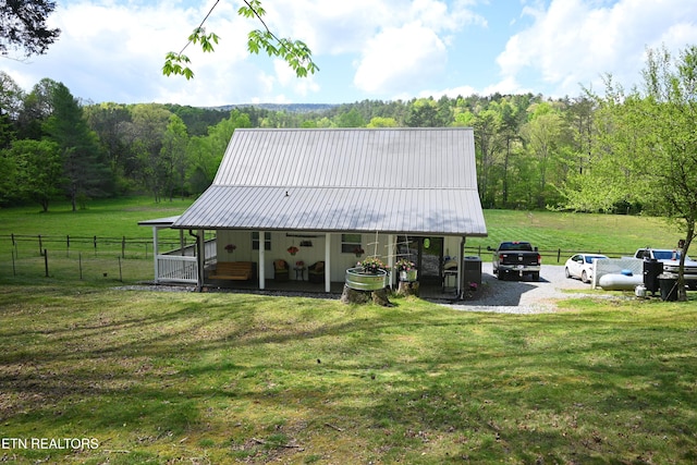 back of house with covered porch and a lawn