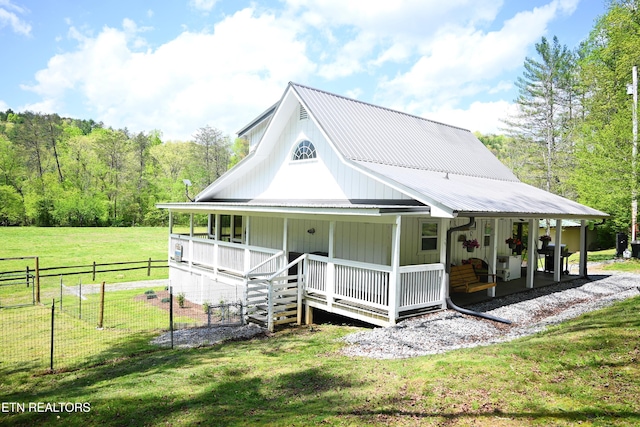 farmhouse with covered porch, a rural view, and a front yard