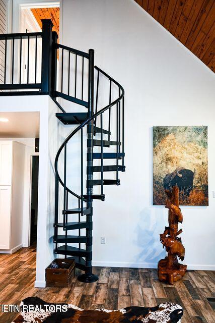 stairway with hardwood / wood-style flooring, high vaulted ceiling, and wood ceiling