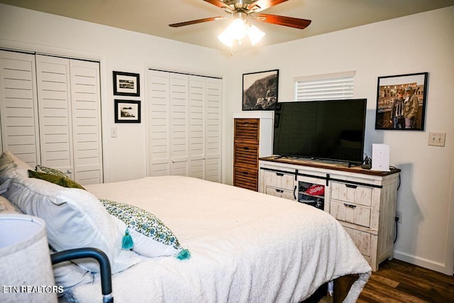 bedroom with ceiling fan, multiple closets, and dark hardwood / wood-style floors