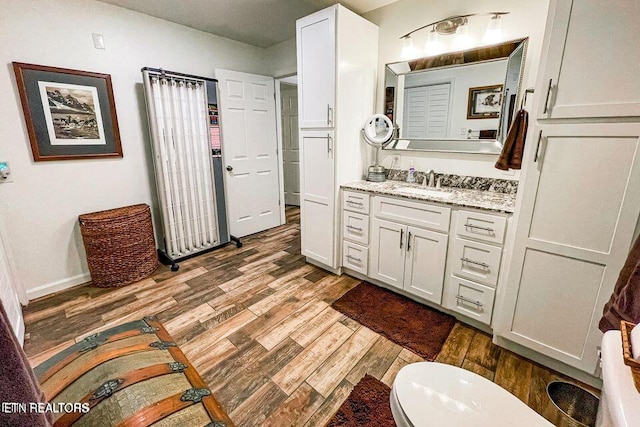 bathroom featuring hardwood / wood-style floors, toilet, and vanity