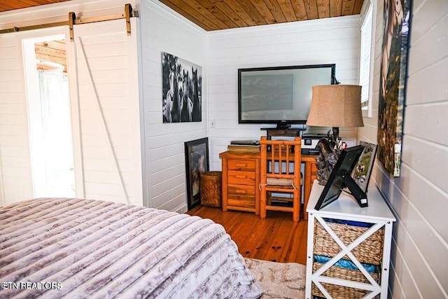 bedroom with wood ceiling, dark hardwood / wood-style flooring, and a barn door