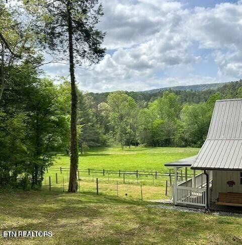 view of yard featuring a rural view and an outbuilding