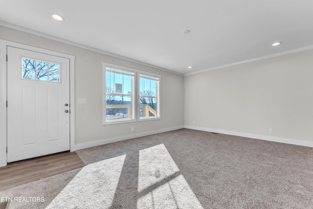 entrance foyer featuring light carpet and ornamental molding