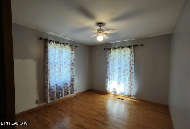 unfurnished room with hardwood / wood-style floors and ceiling fan