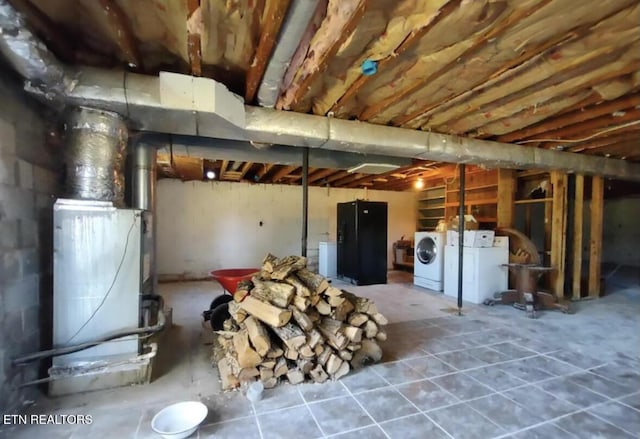 basement with washing machine and clothes dryer and black refrigerator