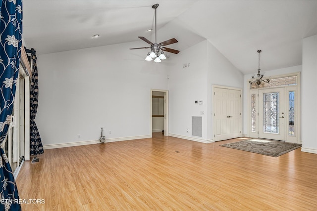 foyer entrance with hardwood / wood-style floors, ceiling fan with notable chandelier, and high vaulted ceiling