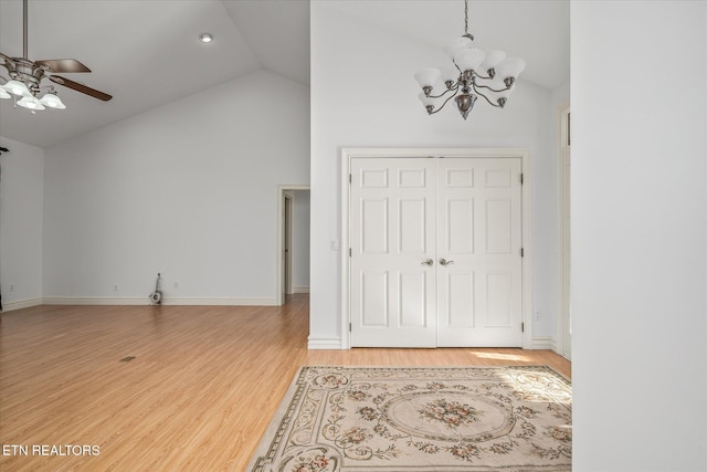 entryway with hardwood / wood-style floors, ceiling fan with notable chandelier, and vaulted ceiling