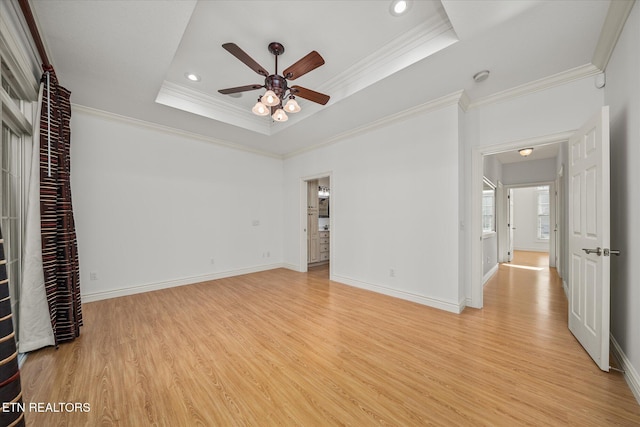 unfurnished bedroom with light wood-type flooring, a raised ceiling, ceiling fan, and crown molding