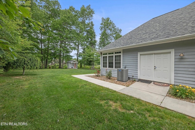 view of yard featuring a storage shed and central air condition unit