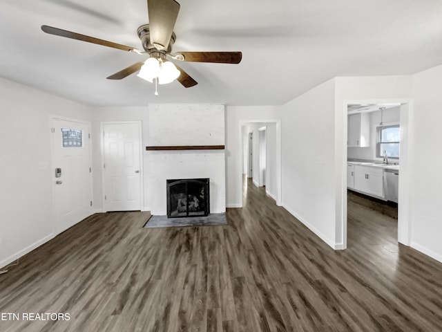 unfurnished living room featuring ceiling fan, a fireplace, and dark hardwood / wood-style floors