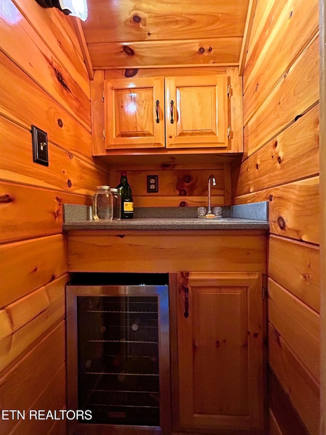 bar with wine cooler, wooden ceiling, and wood walls