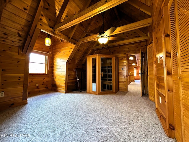 additional living space with light carpet, lofted ceiling with beams, wooden ceiling, and wood walls