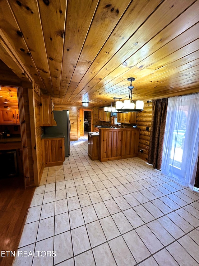 kitchen with decorative light fixtures, wooden ceiling, rustic walls, and stainless steel refrigerator