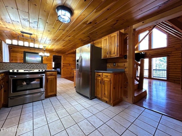 kitchen with wood walls, pendant lighting, light tile patterned floors, wood ceiling, and appliances with stainless steel finishes