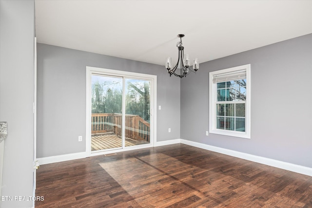 unfurnished dining area with a notable chandelier and dark hardwood / wood-style floors