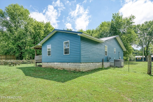 view of side of property with central AC unit and a lawn