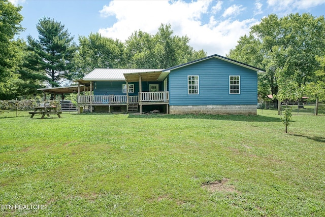 rear view of house with a yard and a porch