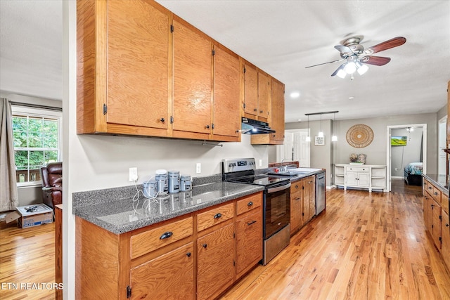 kitchen featuring hanging light fixtures, ceiling fan, dark stone countertops, light hardwood / wood-style floors, and stainless steel appliances