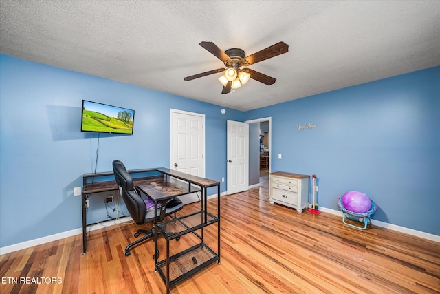 office featuring a textured ceiling, light hardwood / wood-style floors, and ceiling fan