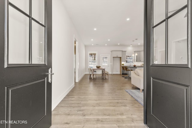 foyer entrance with baseboards, light wood-style flooring, and recessed lighting