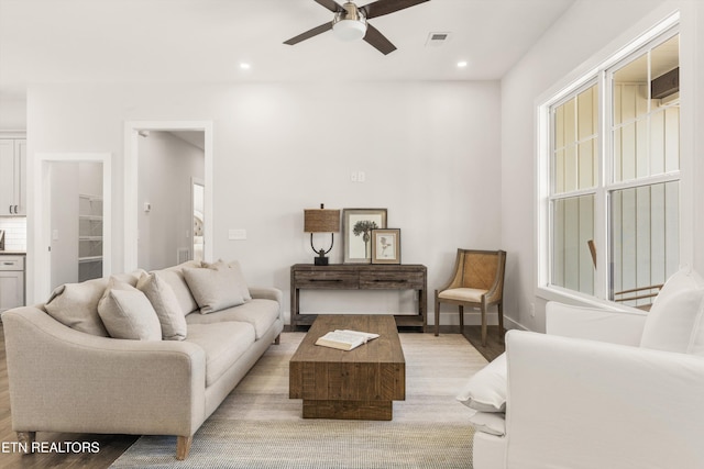 living room featuring visible vents, baseboards, light wood-style flooring, ceiling fan, and recessed lighting