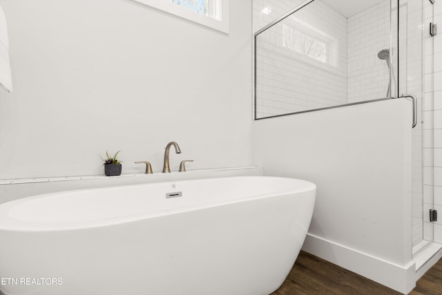 full bathroom featuring a shower stall, baseboards, and wood finished floors