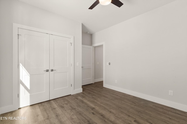 unfurnished bedroom with ceiling fan, a closet, wood finished floors, and baseboards