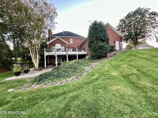 rear view of house featuring a wooden deck and a yard