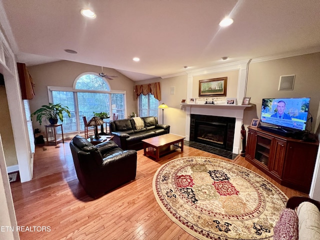 living room with light hardwood / wood-style floors, vaulted ceiling, ceiling fan, and crown molding