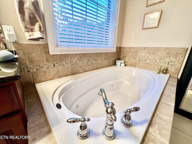 bathroom featuring vanity and a relaxing tiled tub