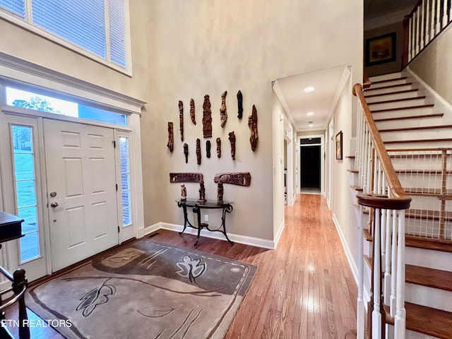 entrance foyer with crown molding and hardwood / wood-style flooring