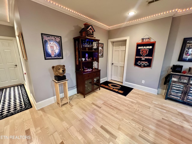 interior space with light hardwood / wood-style flooring and ornamental molding