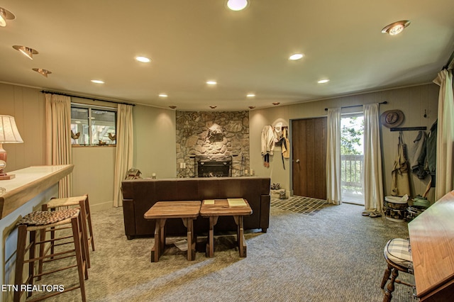 bar featuring a stone fireplace, light colored carpet, and ornamental molding