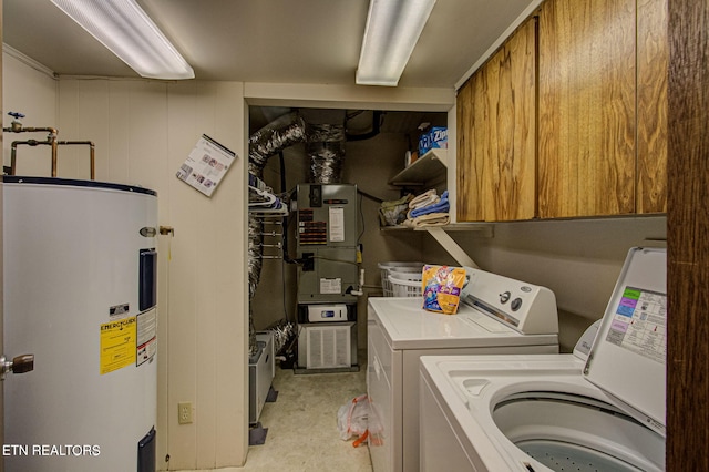 laundry area with cabinets, heating unit, washer and clothes dryer, and water heater