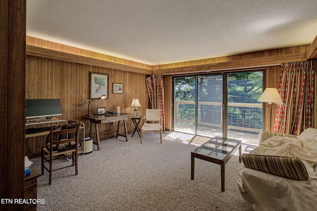 office area featuring wooden walls, carpet, and a textured ceiling