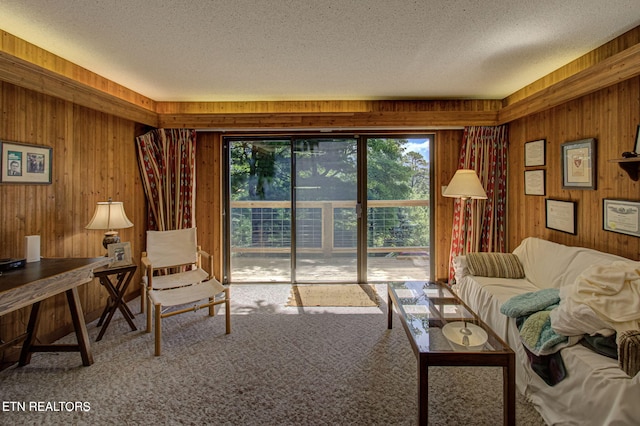 carpeted living room featuring a textured ceiling and wooden walls