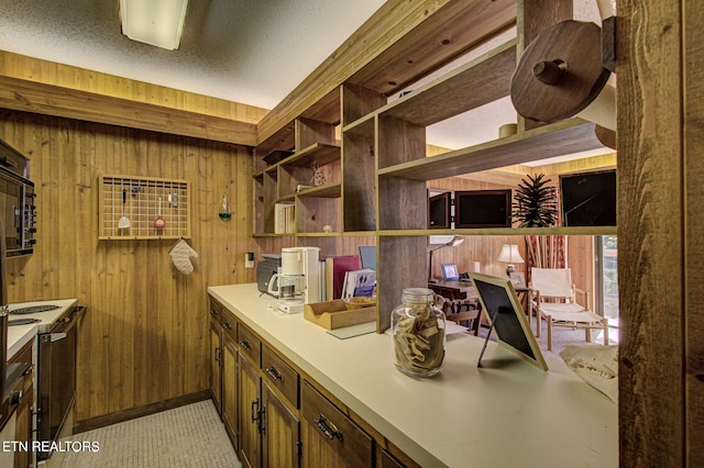 kitchen featuring electric stove and wooden walls