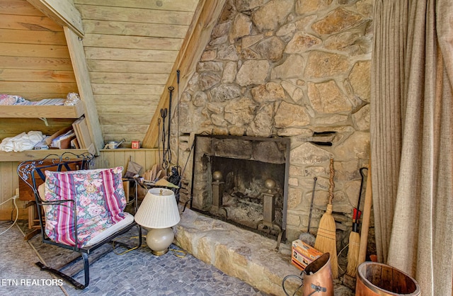 living area with a fireplace, wooden ceiling, and vaulted ceiling