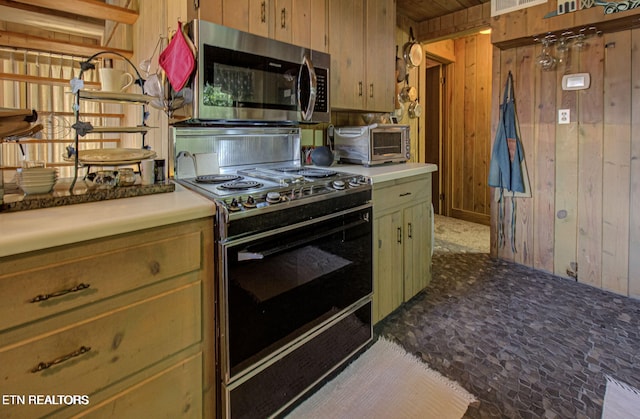 kitchen with black stove and wooden walls