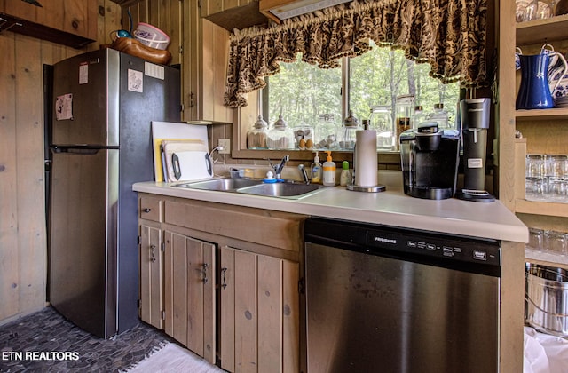 kitchen with wooden walls, sink, and appliances with stainless steel finishes