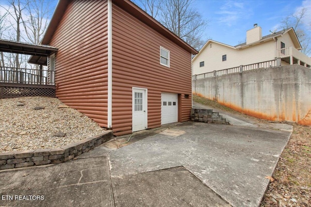 view of home's exterior with a garage and a deck