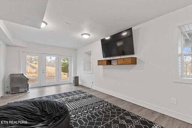 living room featuring french doors, a textured ceiling, and hardwood / wood-style flooring