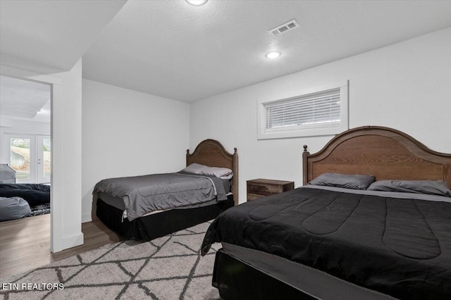 bedroom with a textured ceiling and light wood-type flooring