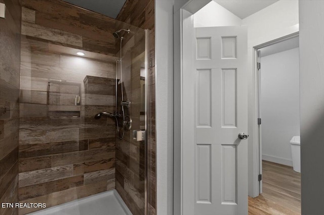 bathroom featuring toilet and a tile shower