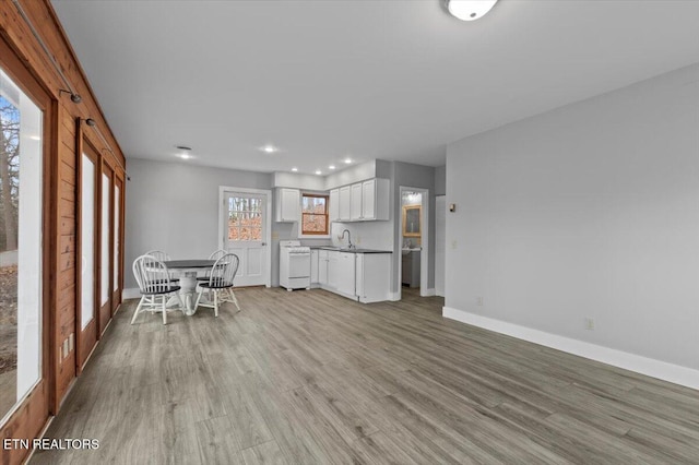 kitchen featuring white cabinets, dishwasher, light wood-type flooring, and sink