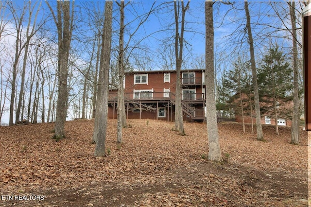 rear view of house featuring a wooden deck