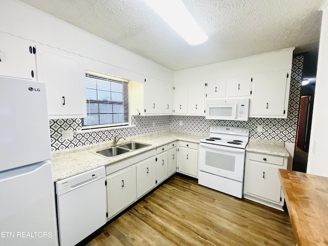 kitchen with white cabinets, a textured ceiling, white appliances, and sink