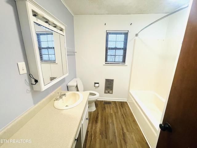 full bathroom with bathtub / shower combination, vanity, a textured ceiling, hardwood / wood-style flooring, and toilet