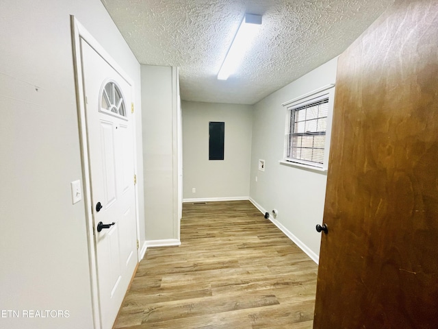 corridor featuring a textured ceiling and light wood-type flooring